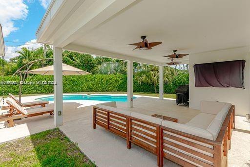 view of swimming pool featuring outdoor lounge area, area for grilling, ceiling fan, and a patio