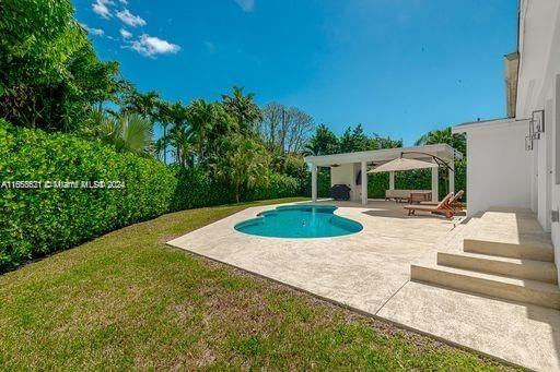 view of pool with a patio area and a yard