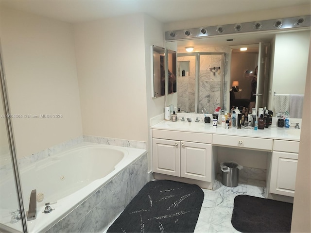 bathroom featuring marble finish floor, a jetted tub, a shower stall, and vanity