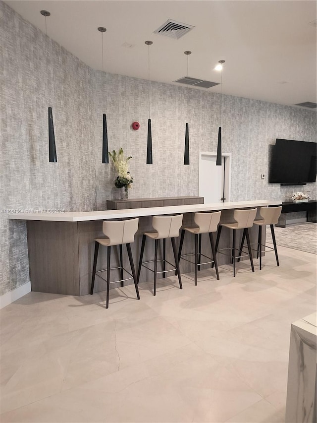 bar featuring decorative light fixtures, visible vents, and wallpapered walls