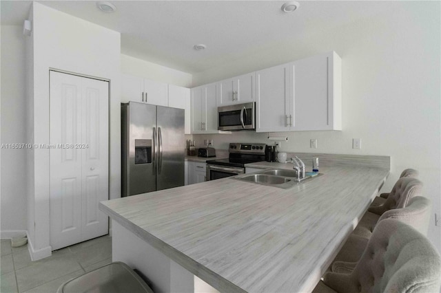 kitchen featuring a breakfast bar, kitchen peninsula, sink, and stainless steel appliances