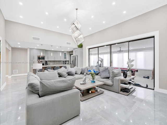 living room featuring crown molding and an inviting chandelier