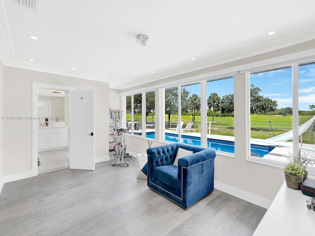 interior space with a wealth of natural light, hardwood / wood-style flooring, and crown molding