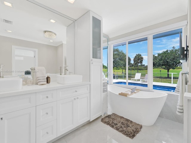 bathroom with a tub, ornamental molding, and vanity