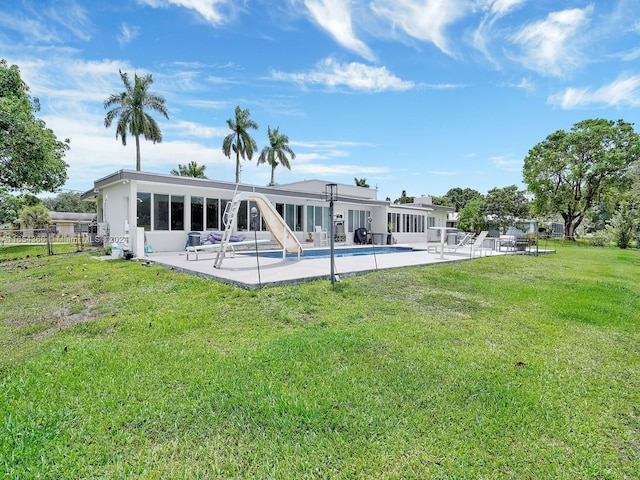 back of property with a lawn and a patio area