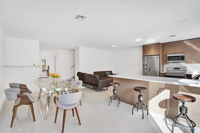 kitchen featuring kitchen peninsula, a kitchen breakfast bar, sink, and appliances with stainless steel finishes