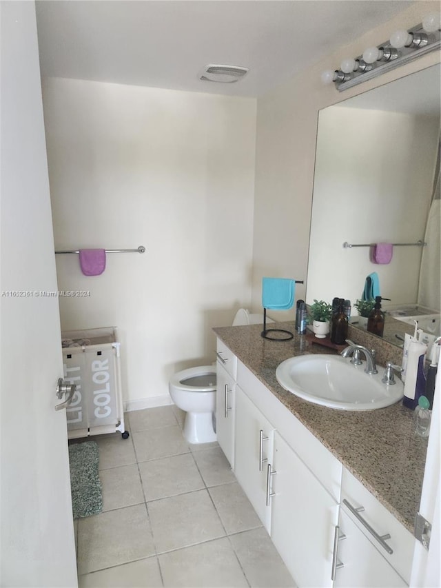 bathroom with vanity, toilet, and tile patterned flooring