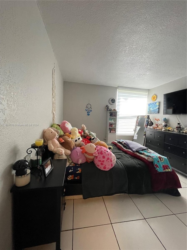 bedroom featuring light tile patterned floors and a textured ceiling