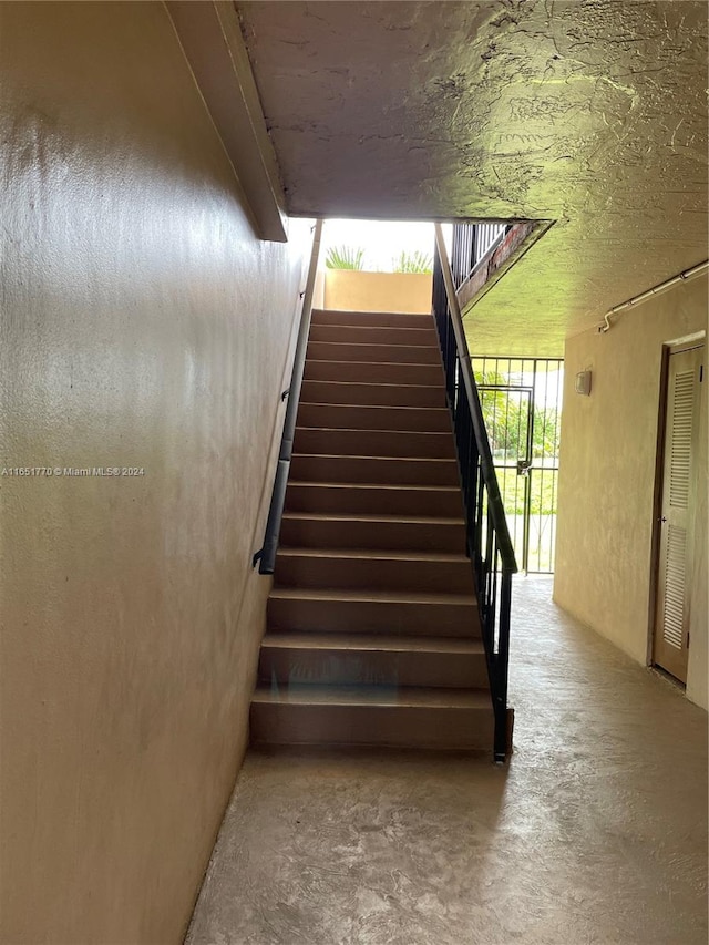 stairway with concrete flooring