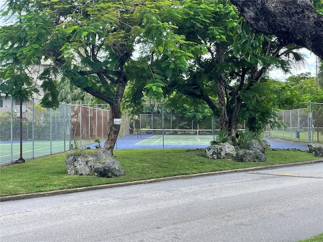 view of sport court with a yard