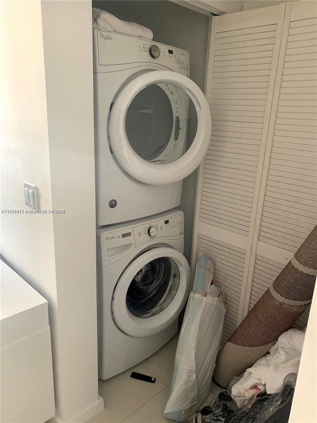 washroom featuring light tile patterned floors and stacked washer and clothes dryer