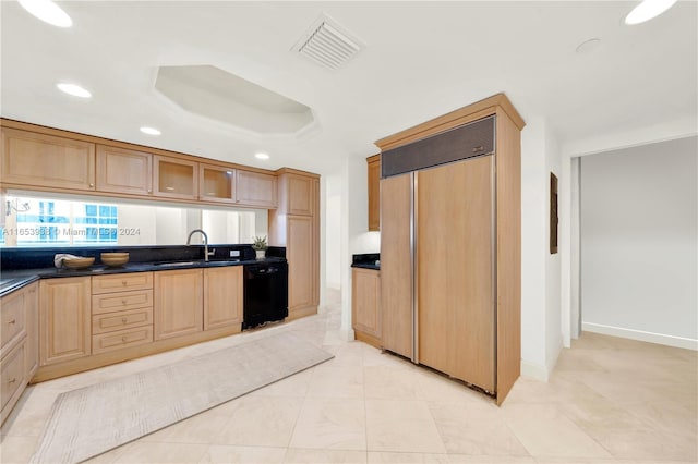 kitchen featuring dishwasher, paneled built in fridge, sink, and a tray ceiling