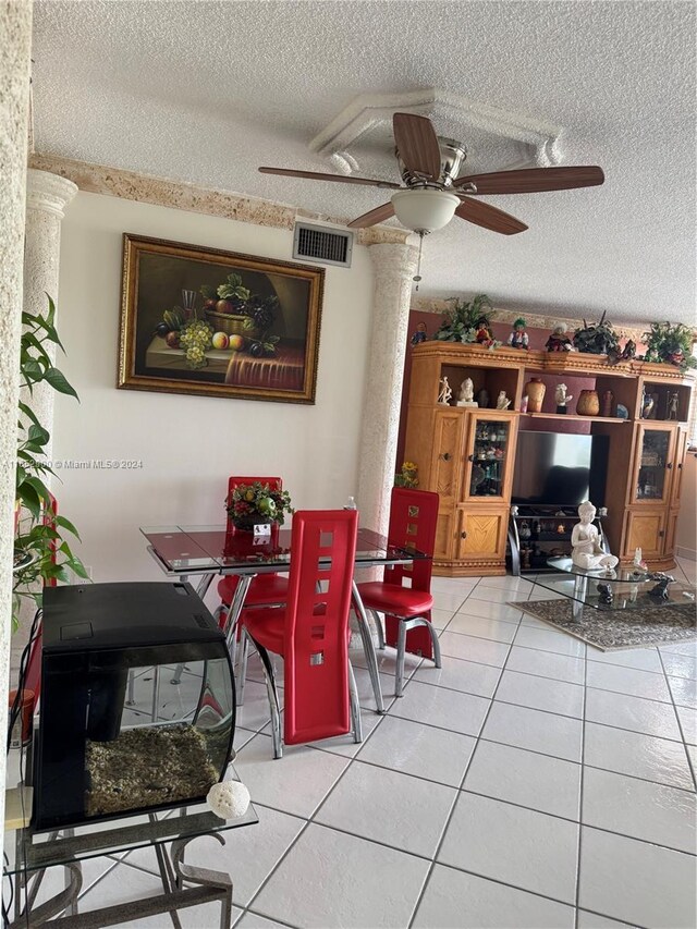 dining space with a textured ceiling, light tile patterned floors, and ceiling fan