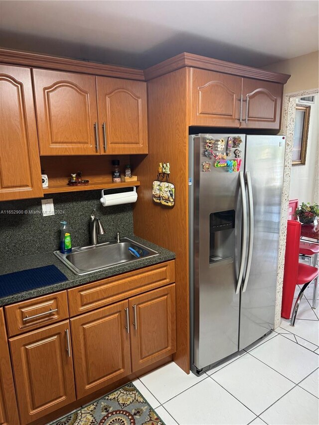 kitchen featuring sink, tasteful backsplash, stainless steel fridge with ice dispenser, and light tile patterned flooring