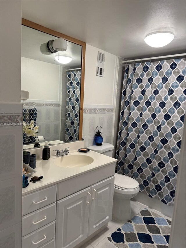 bathroom featuring a textured ceiling, vanity, tile walls, toilet, and tile patterned floors