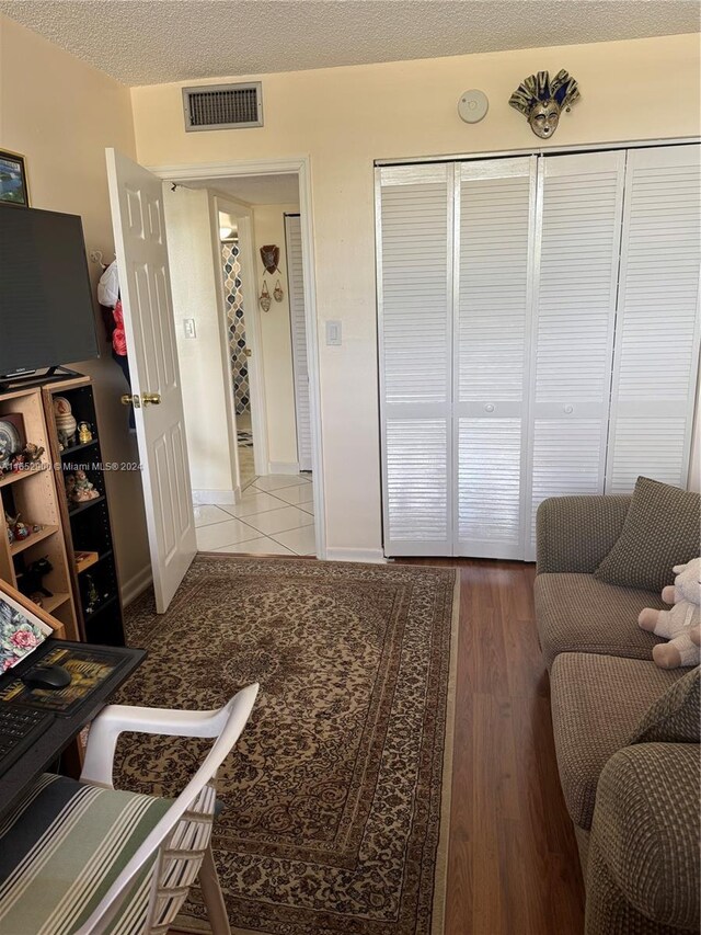 living room with wood-type flooring and a textured ceiling