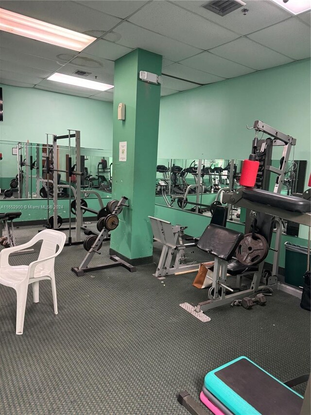 gym featuring carpet and a drop ceiling