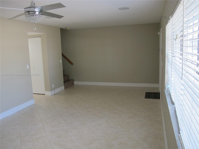 empty room with ceiling fan and light tile patterned floors