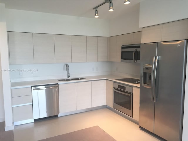 kitchen featuring stainless steel appliances, sink, and track lighting