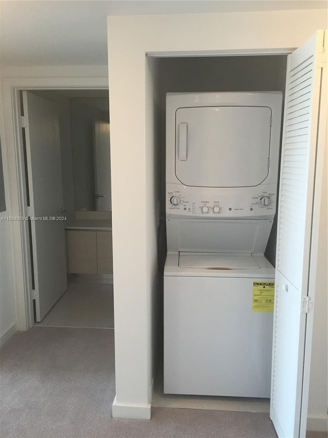 washroom featuring light carpet and stacked washing maching and dryer