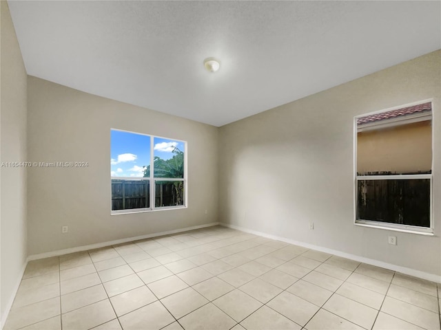 unfurnished room featuring light tile patterned floors and baseboards