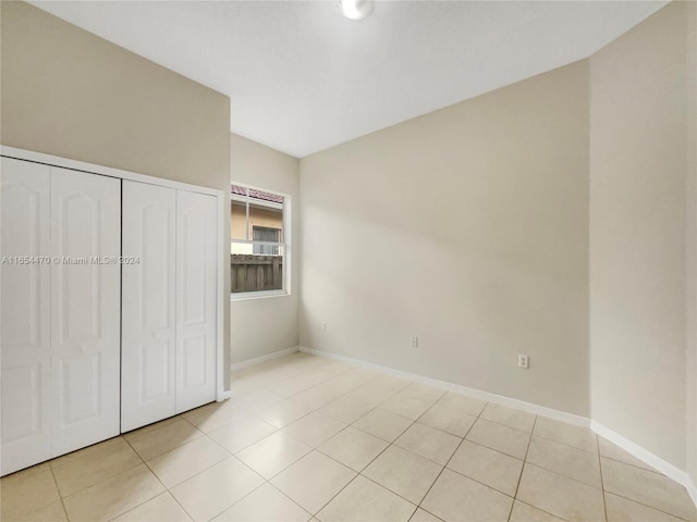 unfurnished bedroom with a closet and light tile patterned floors