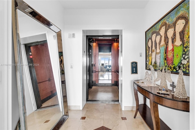 hallway with light tile patterned flooring and elevator