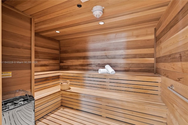 view of sauna / steam room with wood ceiling, wood-type flooring, and wooden walls