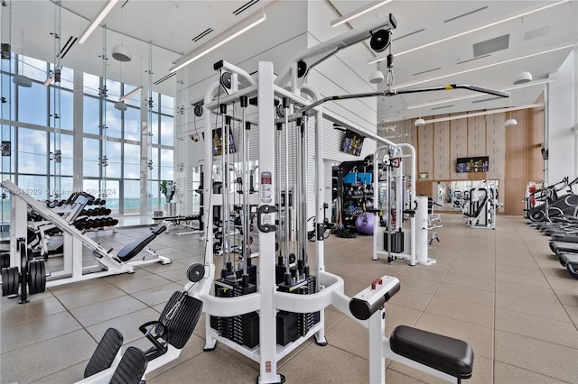 workout area with a towering ceiling and wood walls