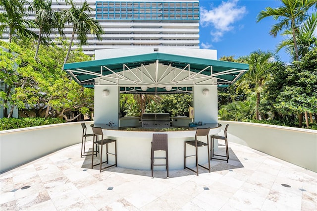 view of patio / terrace with a gazebo, exterior kitchen, a bar, and a grill