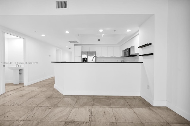 kitchen with white cabinets and appliances with stainless steel finishes