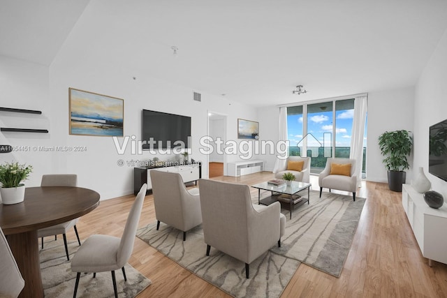 living room featuring floor to ceiling windows and light hardwood / wood-style floors