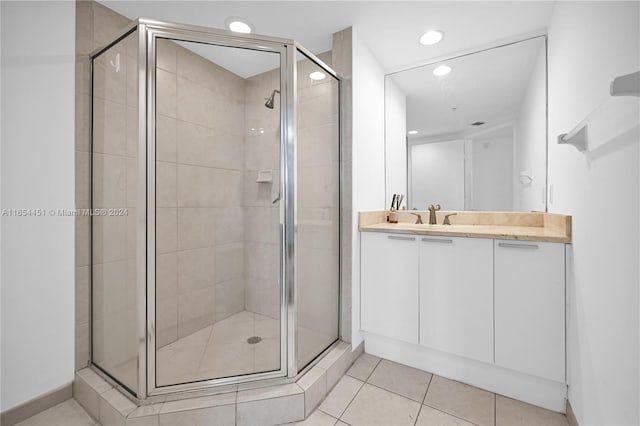 bathroom with vanity, a shower with shower door, and tile patterned floors