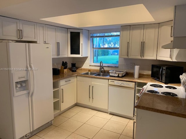 kitchen with white appliances, light tile patterned floors, white cabinetry, and sink