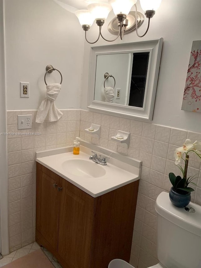 bathroom featuring tile walls, toilet, and vanity