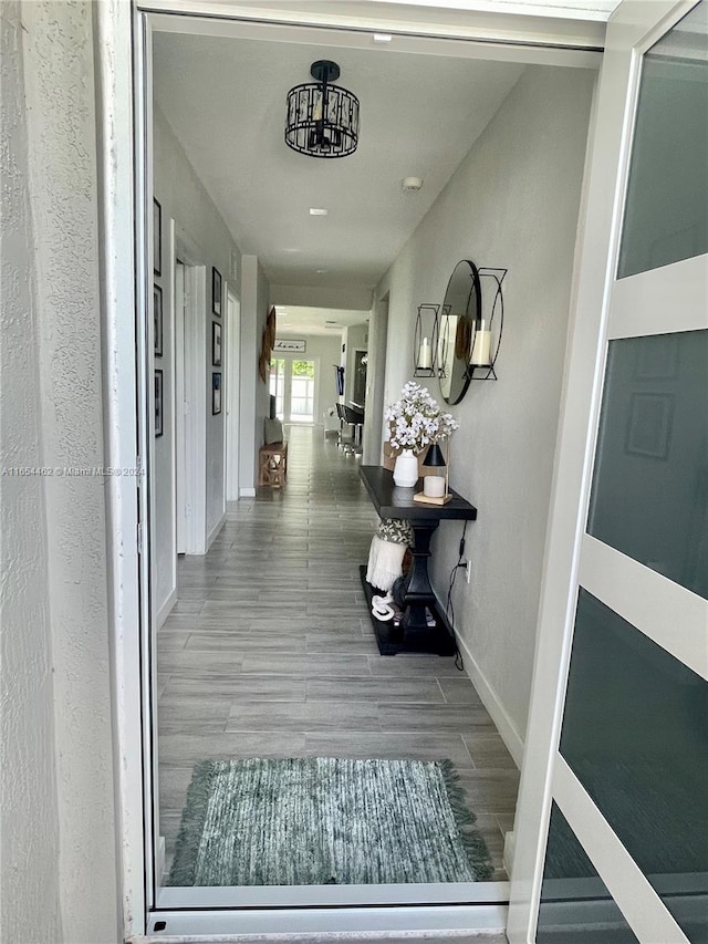 hallway featuring hardwood / wood-style floors and a chandelier