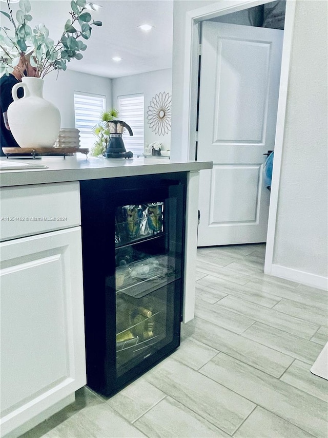 bar with white cabinetry and light hardwood / wood-style floors