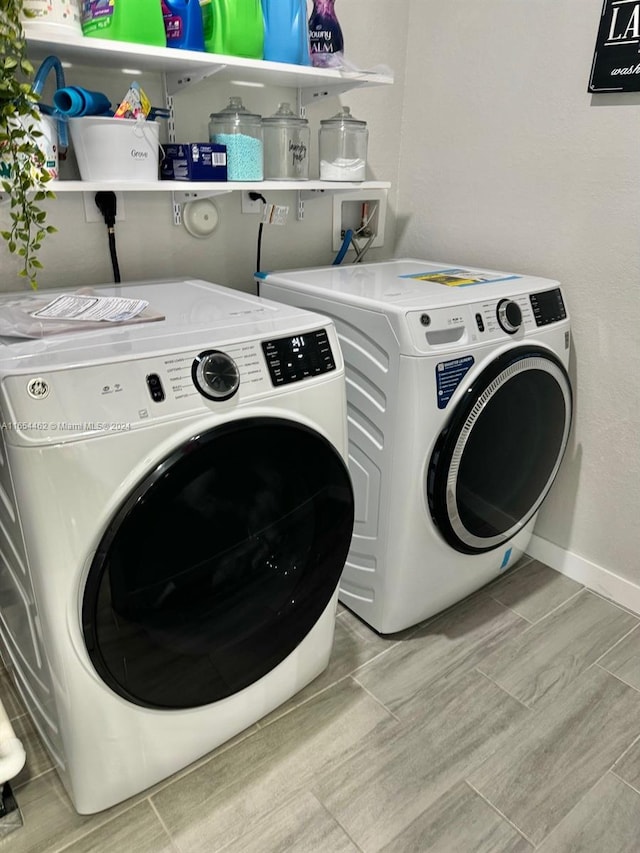 clothes washing area with light wood-type flooring and separate washer and dryer