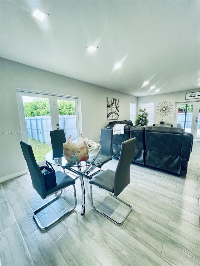 dining space with light wood-type flooring and french doors