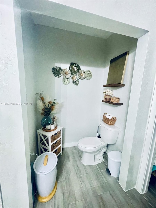 bathroom with wood-type flooring and toilet