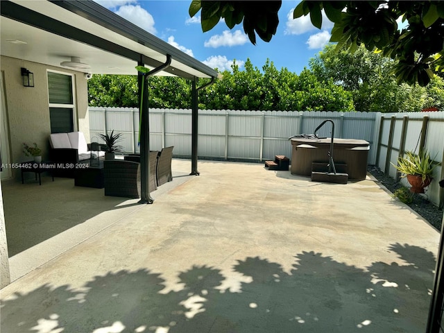 view of patio / terrace with a hot tub, an outdoor living space, and ceiling fan