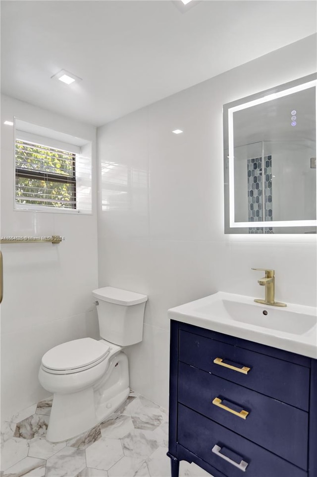 bathroom featuring a shower with shower door, toilet, and vanity