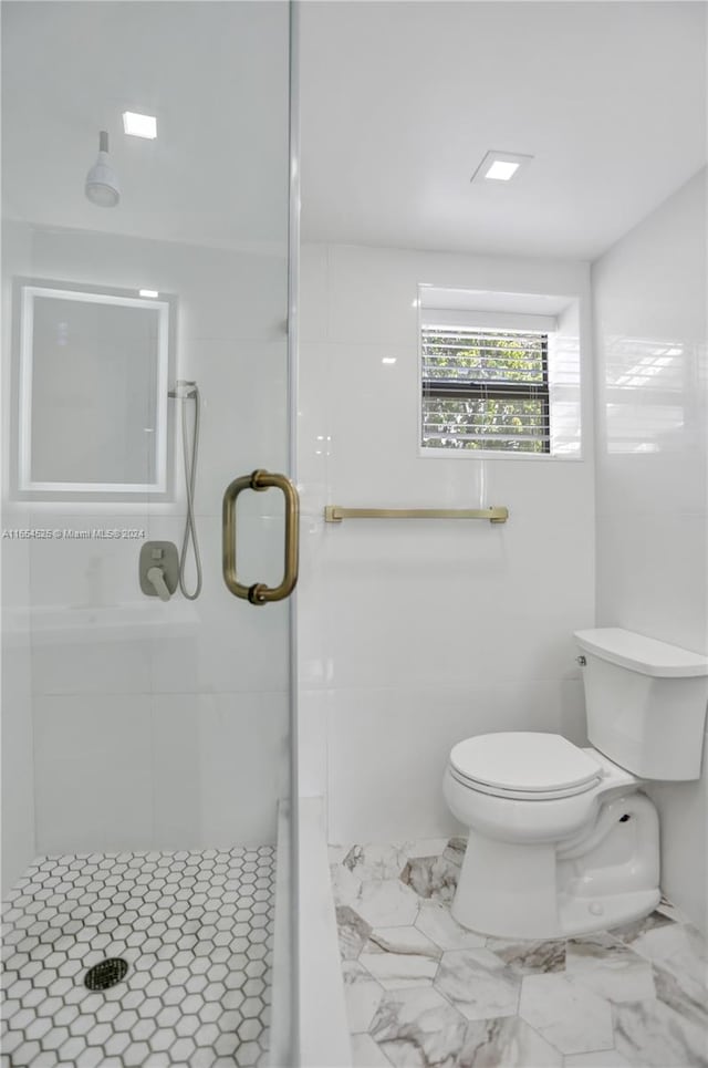 bathroom featuring an enclosed shower and toilet