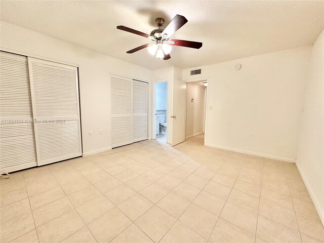 8650 SW 67th Ave Unit 1032, Pinecrest, FL 33156 - unfurnished bedroom with baseboards, light tile patterned flooring, a ceiling fan, and a textured ceiling