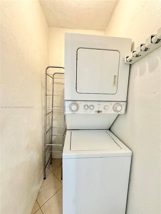 washroom featuring light tile patterned floors and stacked washer and dryer