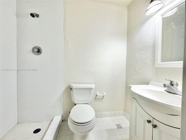 bathroom featuring vanity, toilet, tiled shower, and tile patterned floors