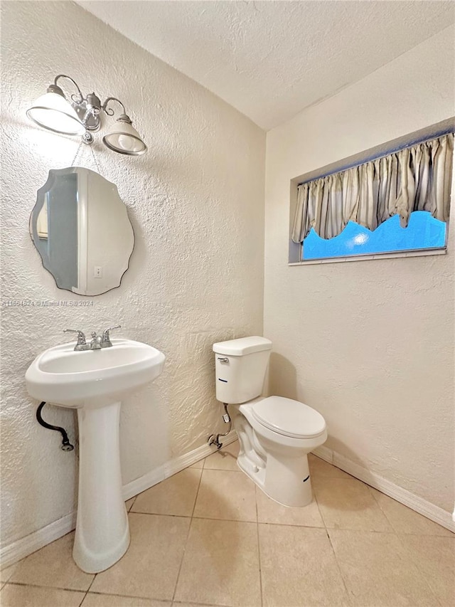 bathroom featuring a textured ceiling, toilet, and tile patterned floors