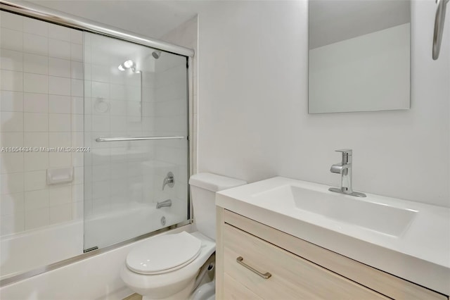 full bathroom featuring shower / bath combination with glass door, vanity, and toilet