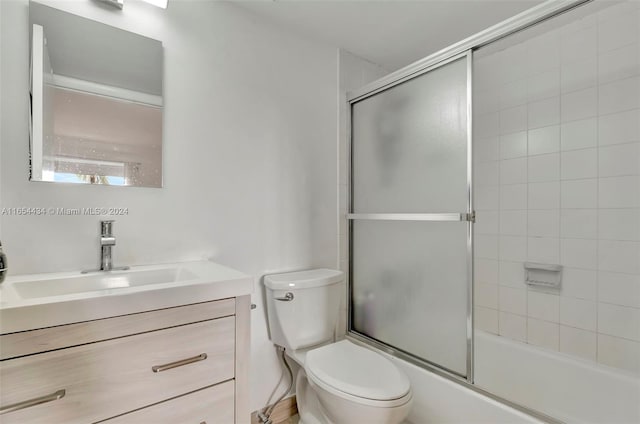 full bathroom with shower / bath combination with glass door, toilet, and vanity