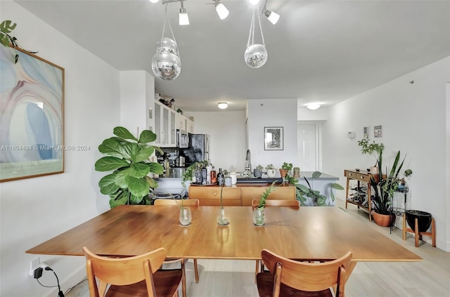 dining area featuring sink and light hardwood / wood-style floors